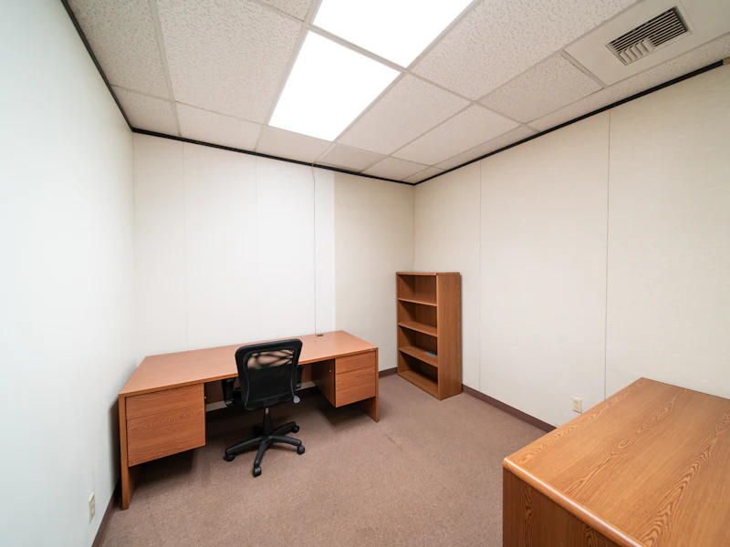 Geräumtes Büro mit Schreibtisch und Regal nach einer Firmenauflösung