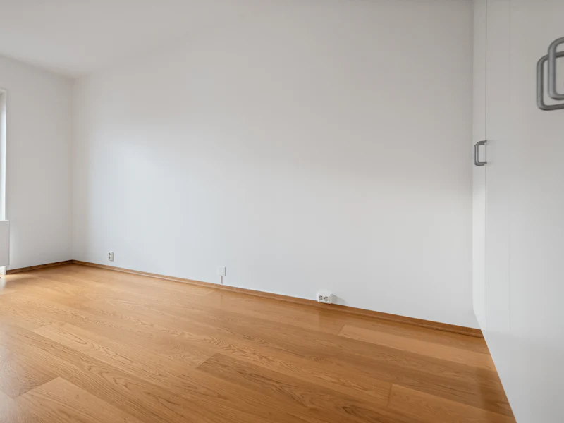 Wohnzimmer mit Sofa, Sesseln und Teppich – leer und sauber (nachher, Symbolbild)